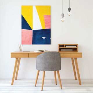 A canvas print hanging above a reading desk.