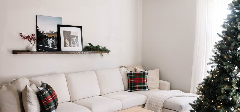 A canvas print hanging above a couch, facing a Christmas tree
