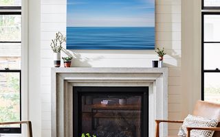 A canvas print positioned above a fireplace.