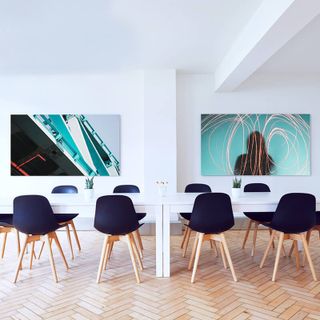 Two large canvas prints positioned above meeting room tables.