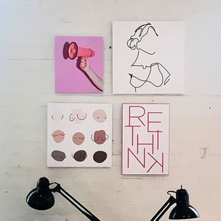 Four small abstract canvas prints on a wall.