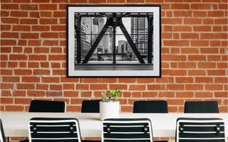 A framed print positioned above a meeting room table.
