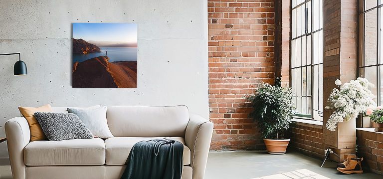 A metal print hanging above a couch next to an accent wall.