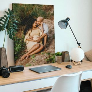 A canvas print on top of a computer desk.