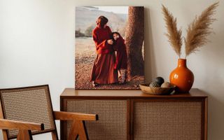 Two canvas print hanging in living room. One of young children playing near the lake, the other of a family portrait at the lake.