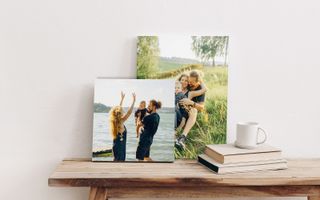 Two canvas print hanging in living room. One of young children playing near the lake, the other of a family portrait at the lake.
