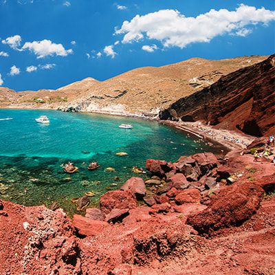 Red, mountainous terrain around a clear blue lake
